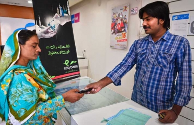 A woman receiving payment for her work through the Easypaisa mobile banking system