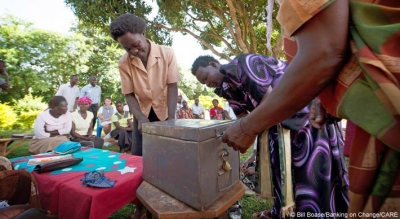 Members of the Yesu Amala VSLA group open the group&rsquo;s shared safe during a meeting of the group&rsquo;s members in Busia District, Eastern Uganda