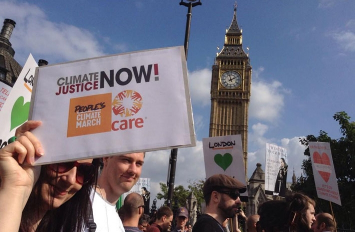 Catherine Pettengell holding a placard as the marchers pass Big Ben in London