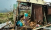 A woman stands in her devastated home after Typhoon Haiyan hit Merida village in the Philippines, November 2013