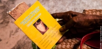 A member of a Village Savings and Loan Associations in Haiti holding her member&#039;s card
